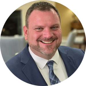 a man in a suit smiling at Treyton Oak Towers